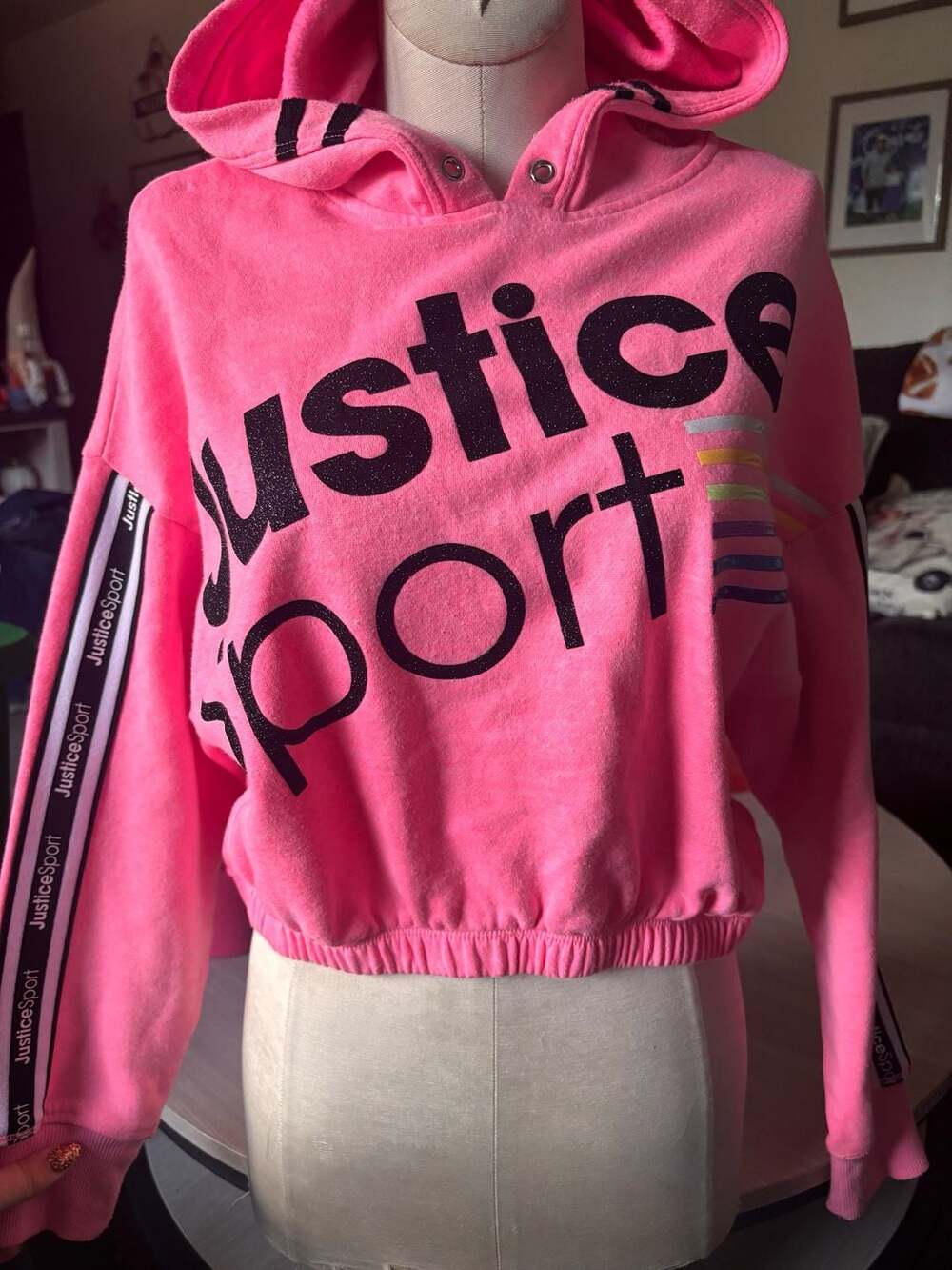 Vibrant pink hoodie with colorful stripe accents....